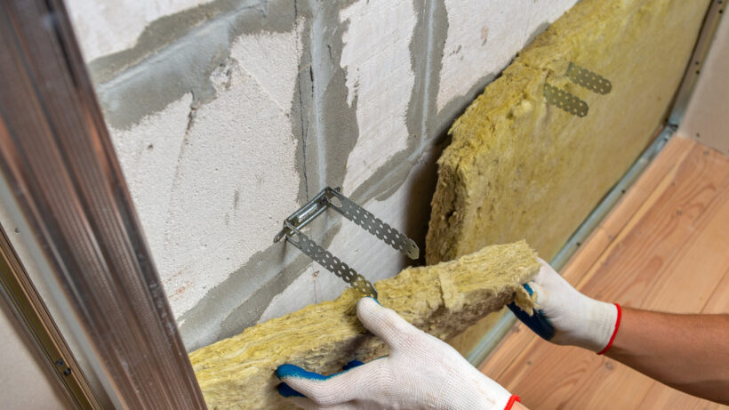 Fotografia de un trabajador instalando material aislante en una pared