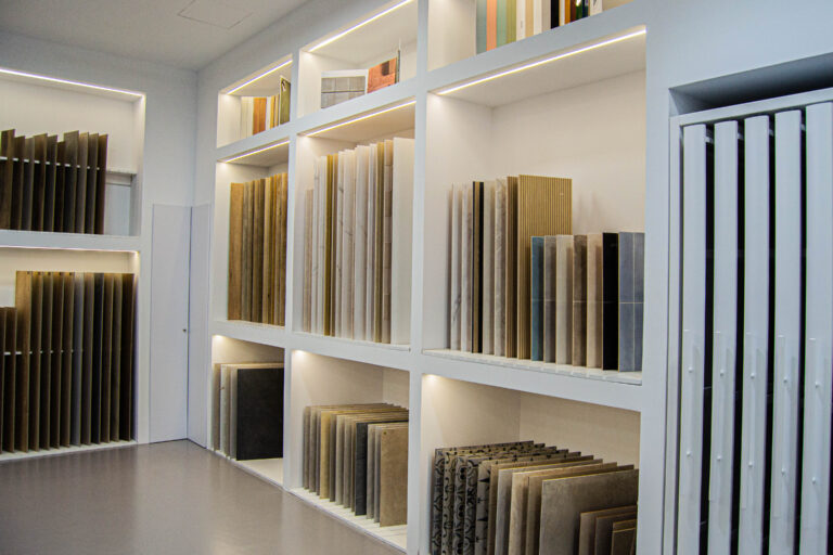 Exposición de muestras cerámicas y pavimentos en el showroom Ari Ceramic de Córdoba, con revestimientos en diferentes colores y texturas.