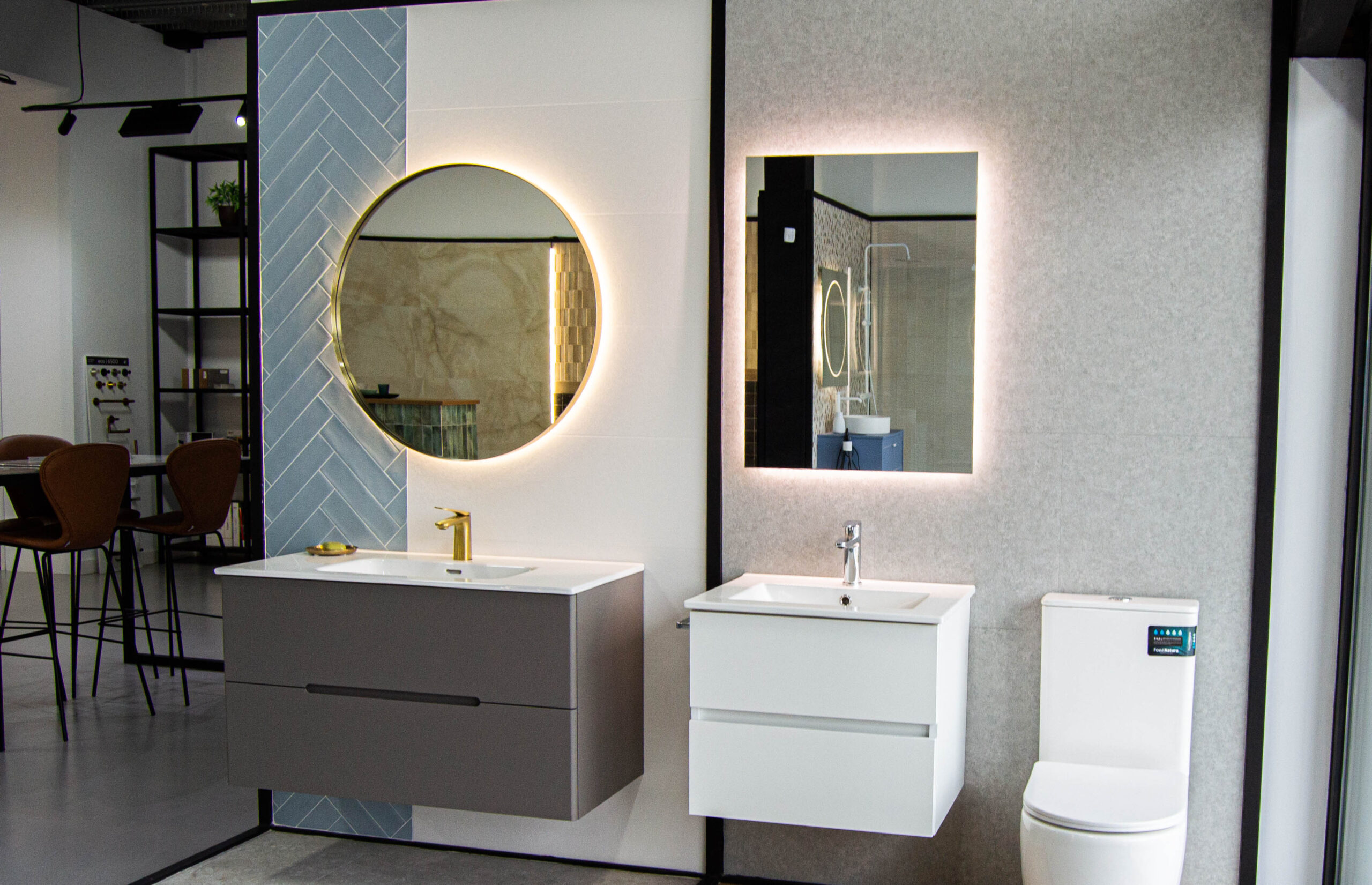 Baño contemporáneo con muebles suspendidos, espejos retroiluminados y revestimientos cerámicos en tonos neutros y azul pastel.